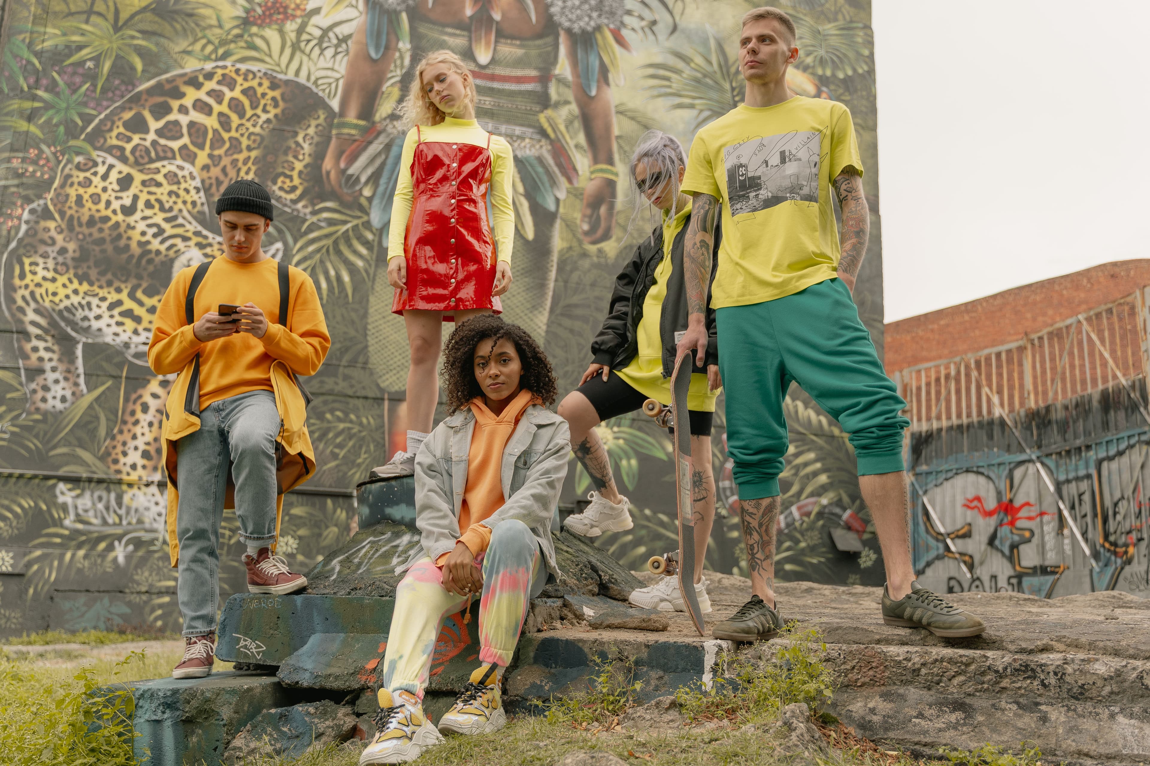 Group in bright streetwear in front of a painted wall