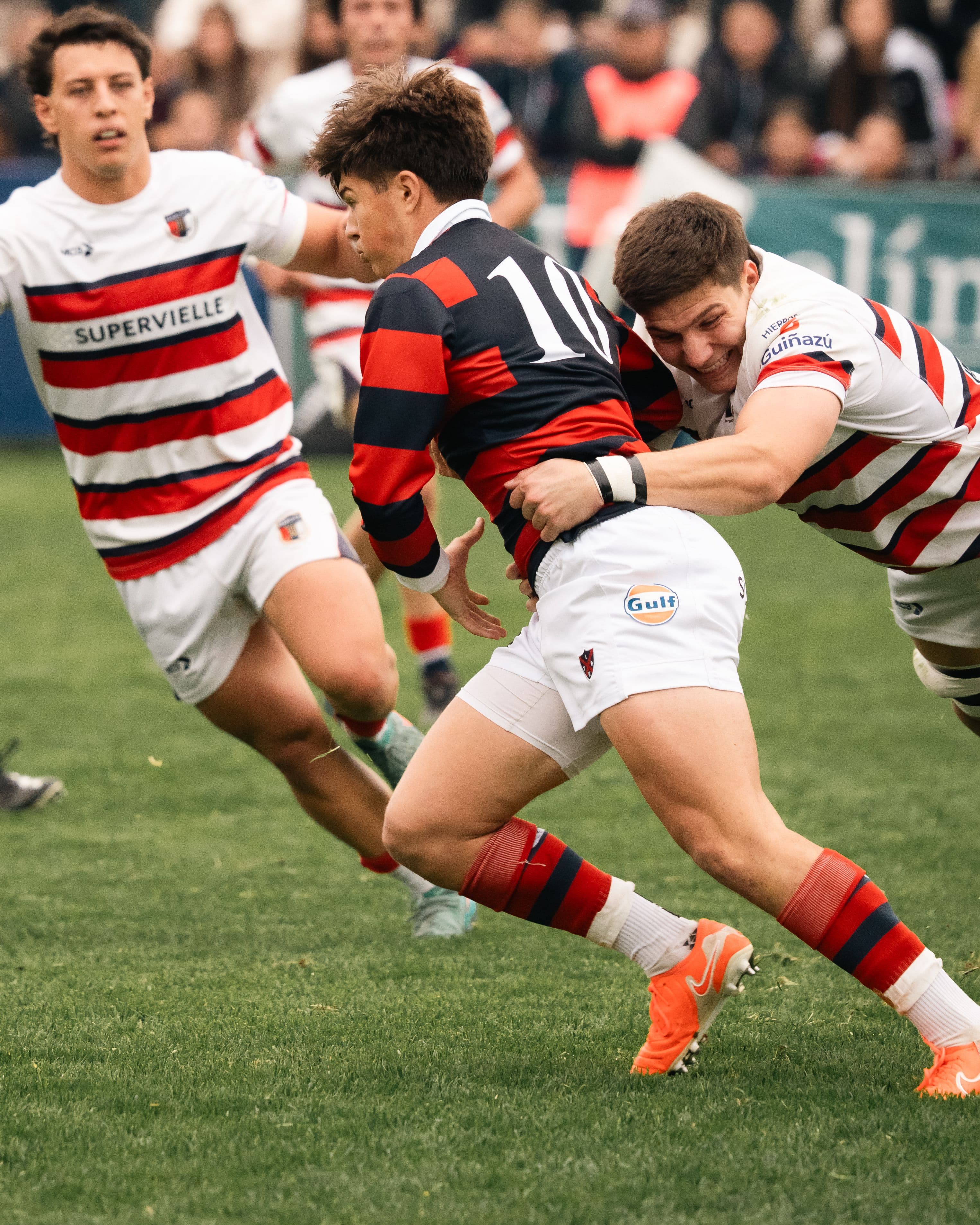 Rugby players in striped kits contesting the ball